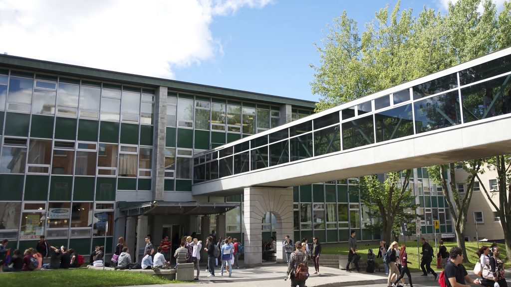 Pavillon A avec passerelle et étudiants à l'extérieur sur le campus